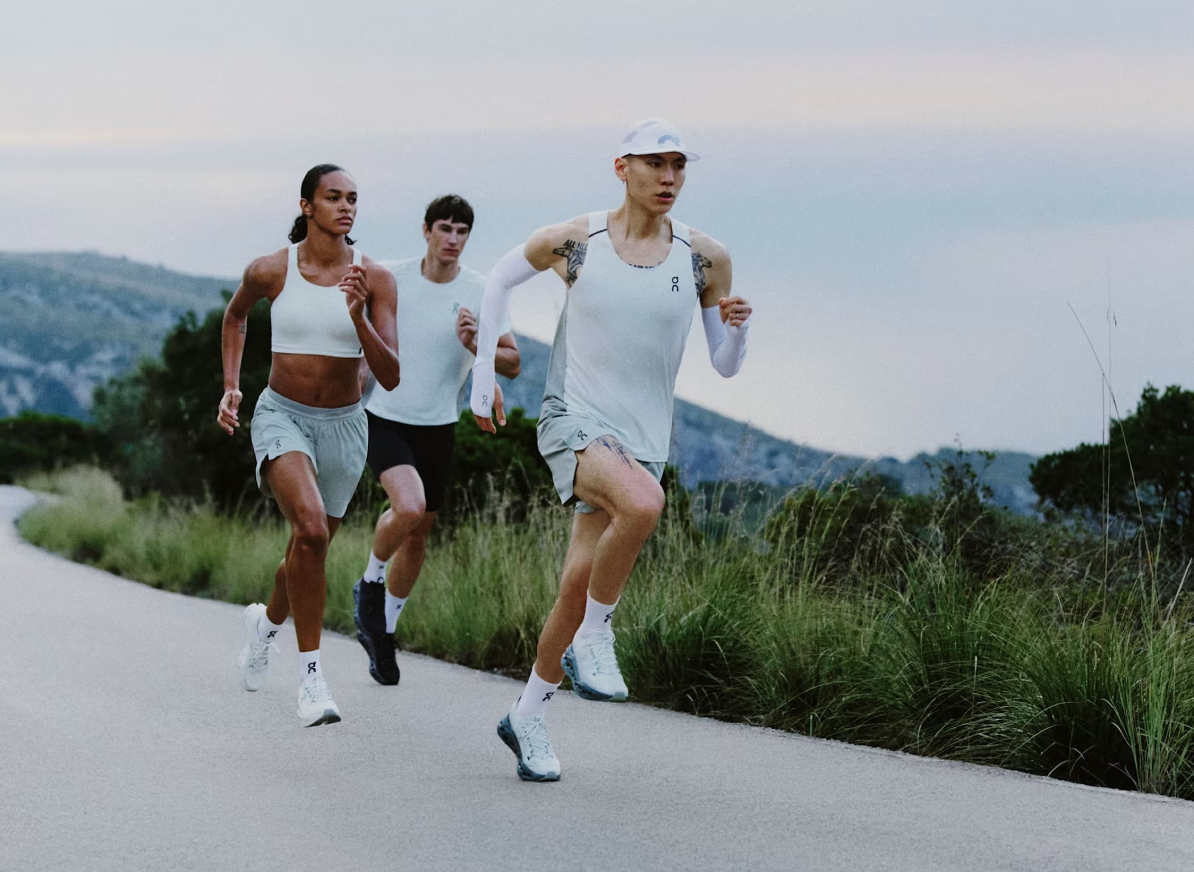 Trois coureurs à l’entraînement sur une route de bord de mer